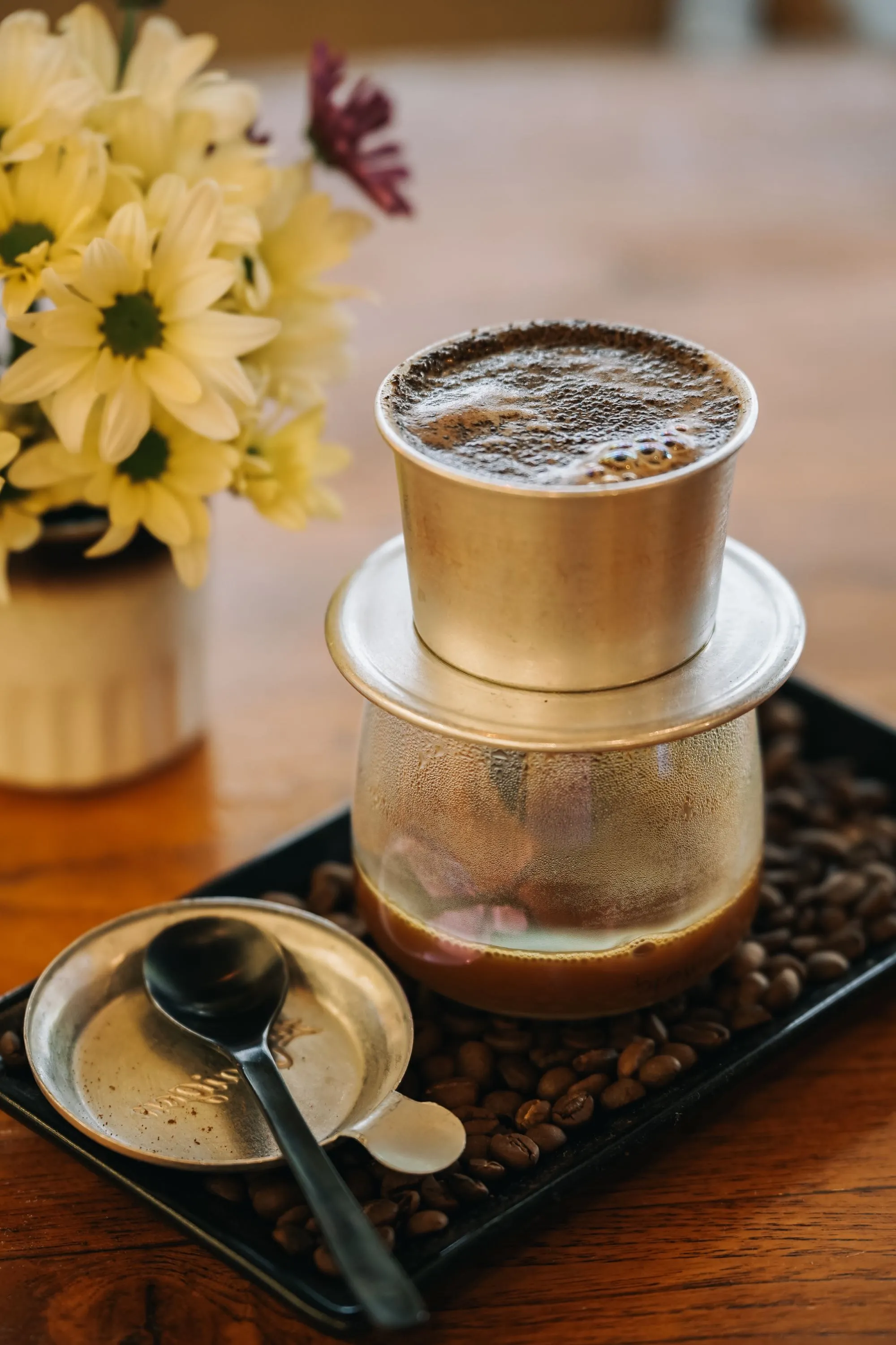 Vietnamese phin dripping fresh coffee over roasted beans